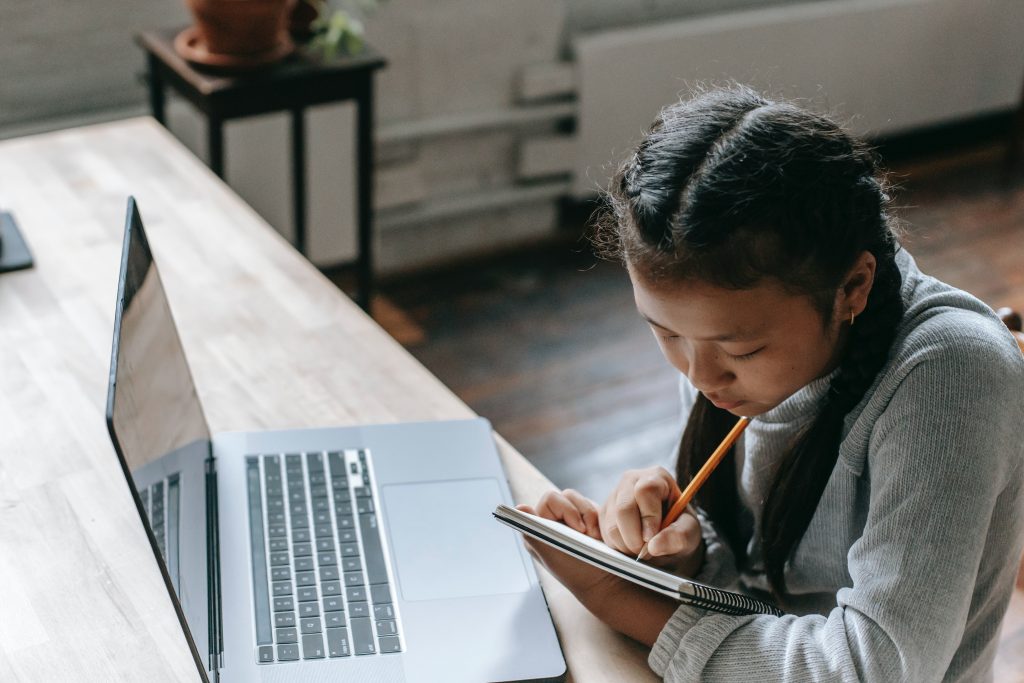 young Brown student working at a laptop